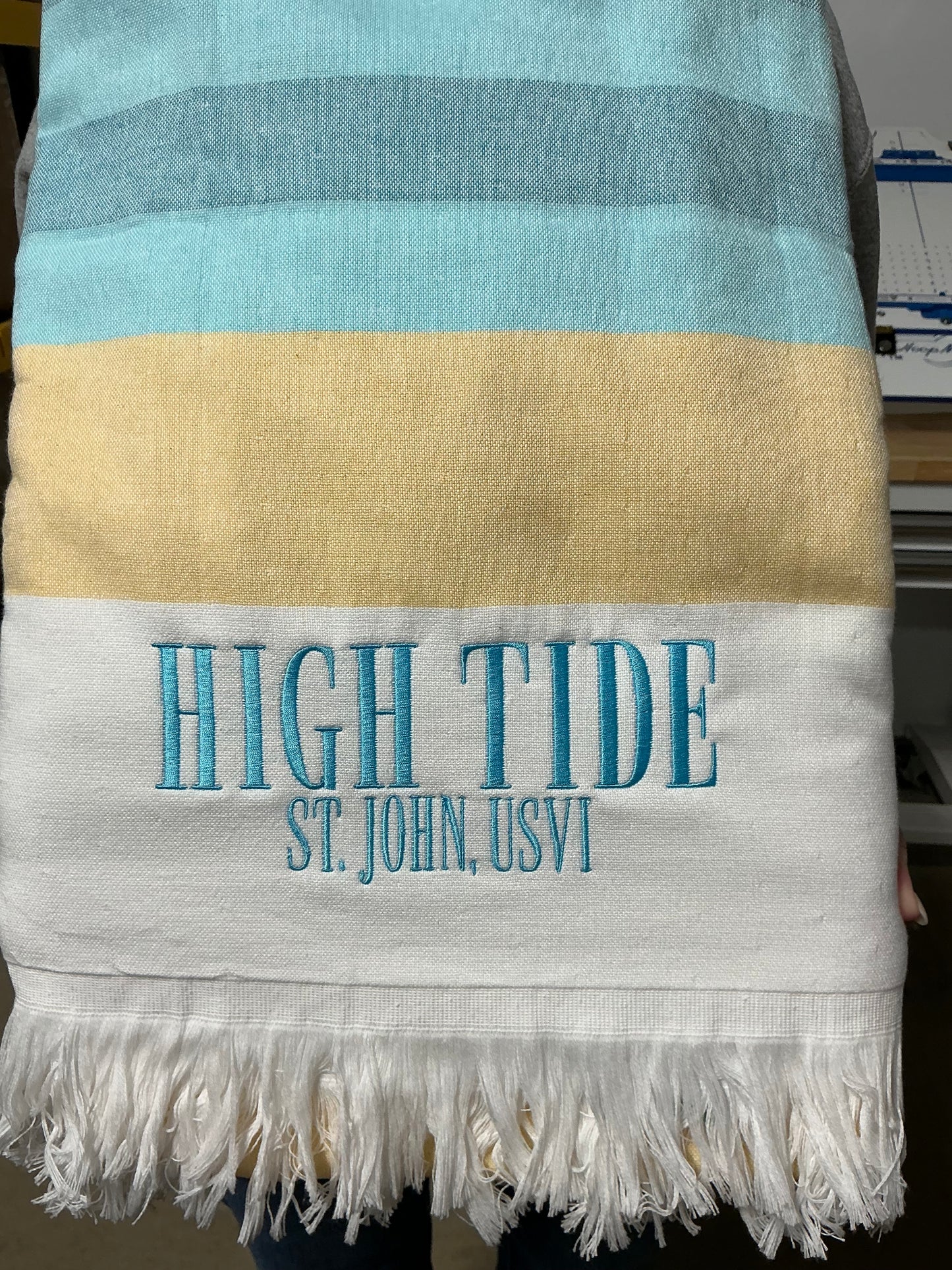 Striped towel with 'High Tide Last John' text on a white background
